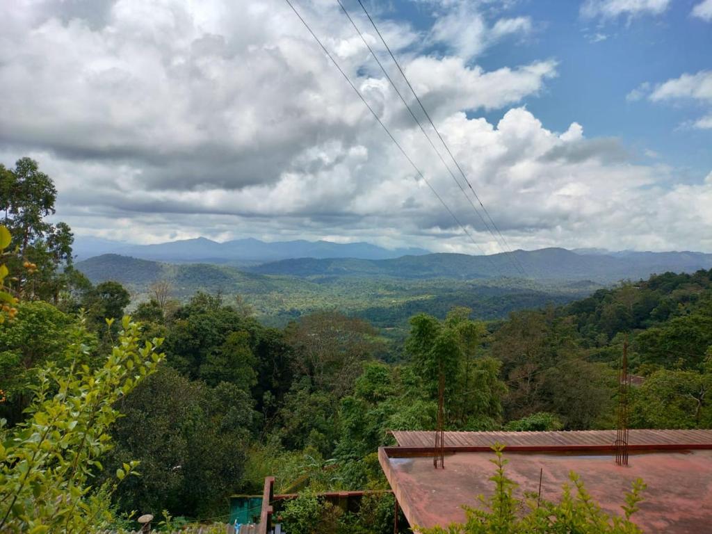 vistas a un valle con montañas a lo lejos en Mountain view pinak stay, en Madikeri