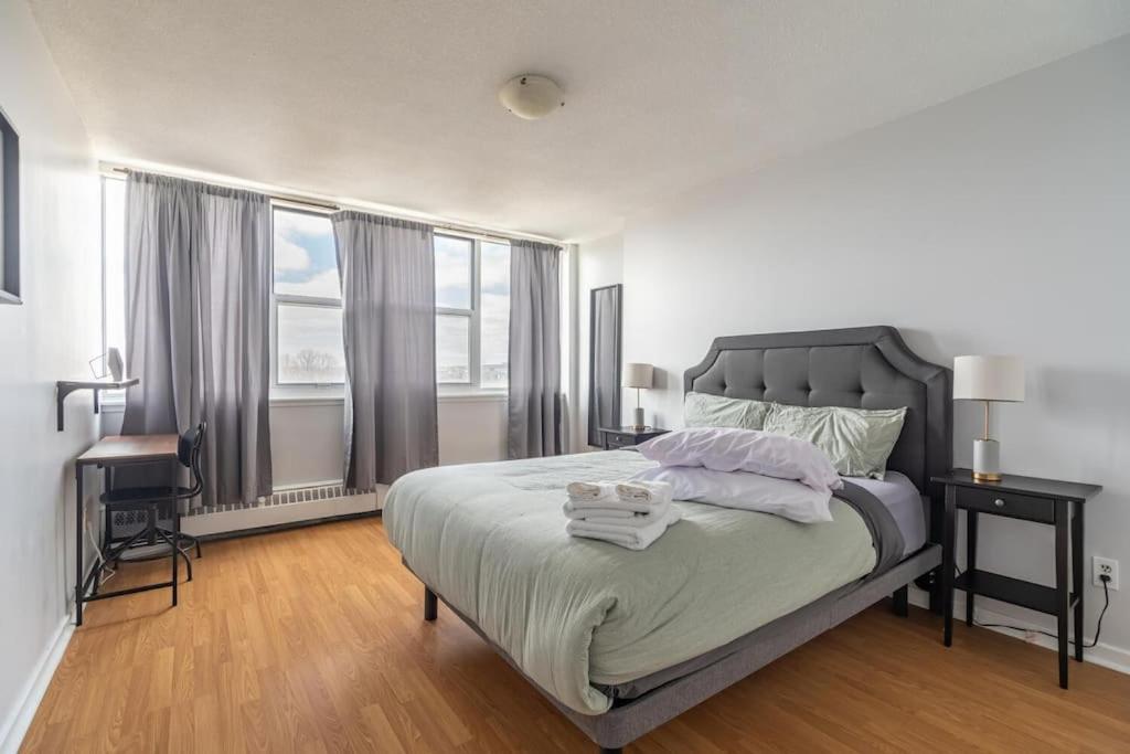 a bedroom with a bed and a large window at Bright DT Apt #7A, Amazing View in Halifax