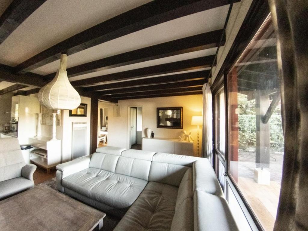 ein Wohnzimmer mit Couch und großem Fenster in der Unterkunft Maison moderne et traditionnelle à 300m de la plage, avec jardin, barbecue et parking privé - FR-1-413-234 in Capbreton