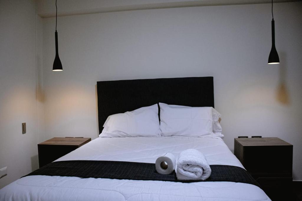 1 dormitorio con 1 cama con 2 toallas en PRANA, en Huancayo