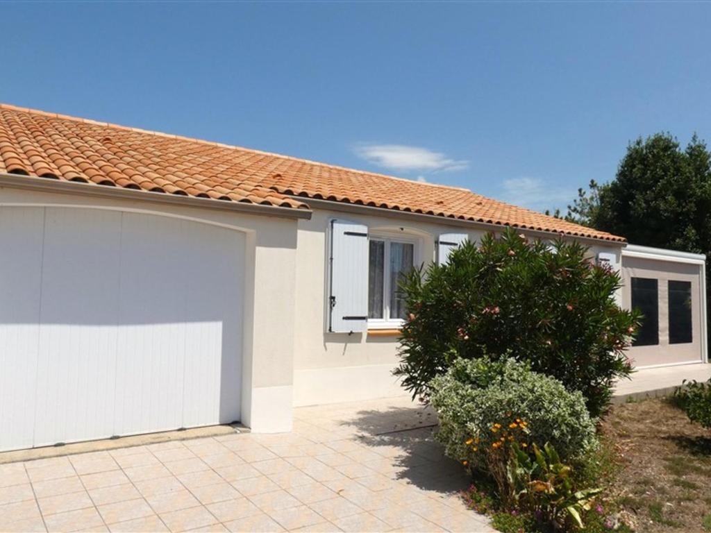 une maison blanche avec un garage dans l'établissement Charmante maison 2 chambres, proche plage, commerces, avec terrasse et WiFi à Saint-Jean-de-Monts - FR-1-323-284, à Saint-Jean-de-Monts