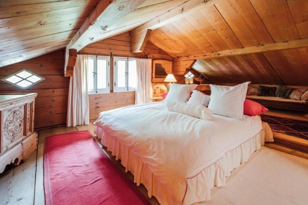 ein Schlafzimmer mit einem Bett in einem Holzzimmer in der Unterkunft Alphütte - Ferienchalet Berner Oberland Schweiz - Fermeltal 20min von Gstaad - b48817 