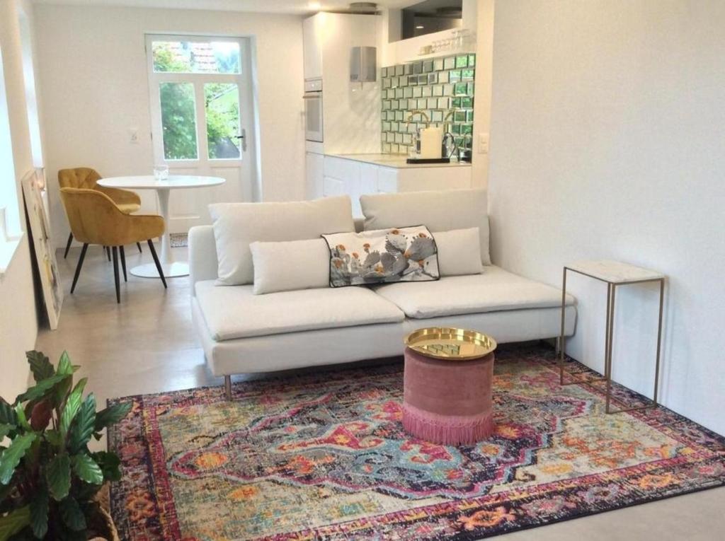 sala de estar con sofá blanco y alfombra en Kleines, cooles Loft im Appenzellerland - b48859, en Gais