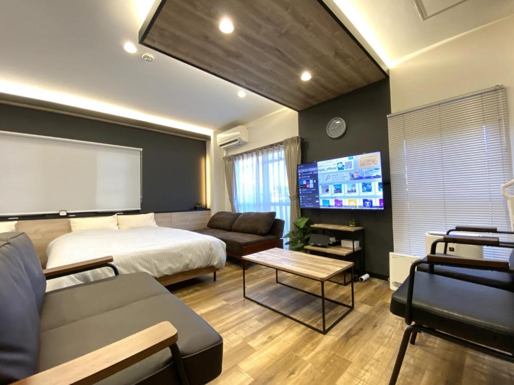 1 dormitorio con cama, sofá y TV en Frontier 1st Building - Vacation STAY 15474, en Kagoshima