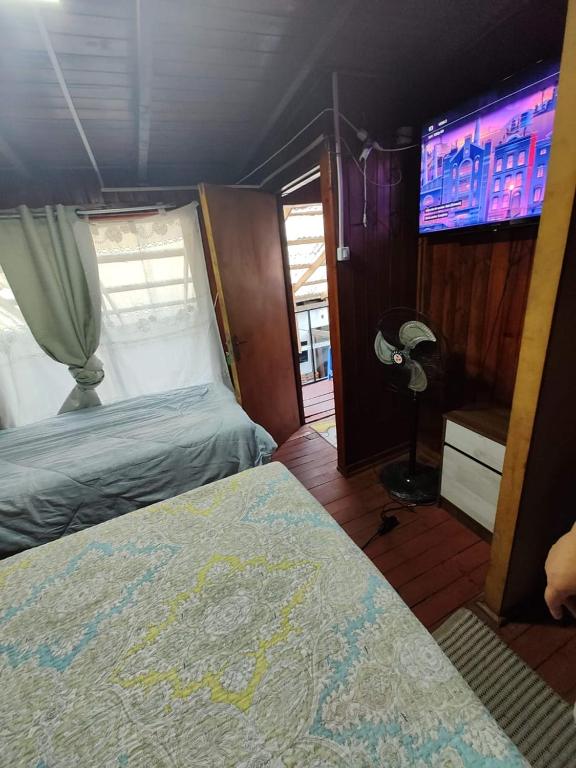 um quarto com uma cama e uma televisão de ecrã plano em Alojamiento chillan em Chillán