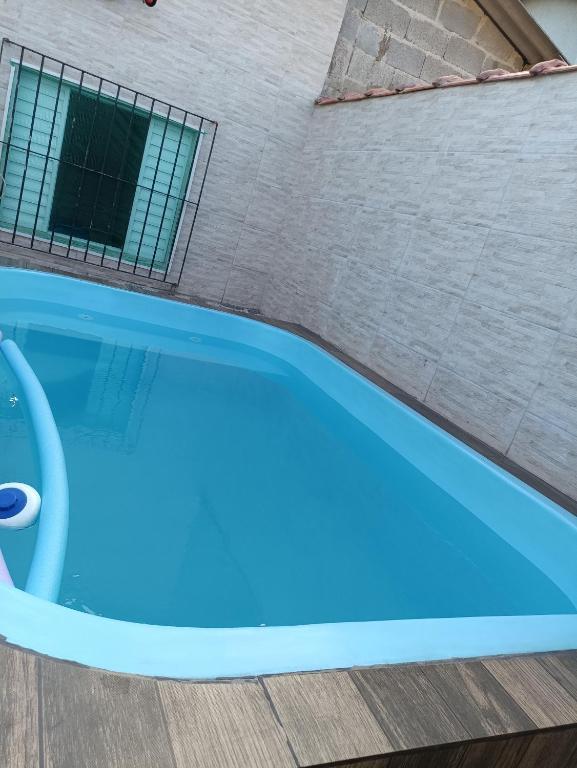 a blue swimming pool next to a building at Casa Praia Mongaguá in Mongaguá