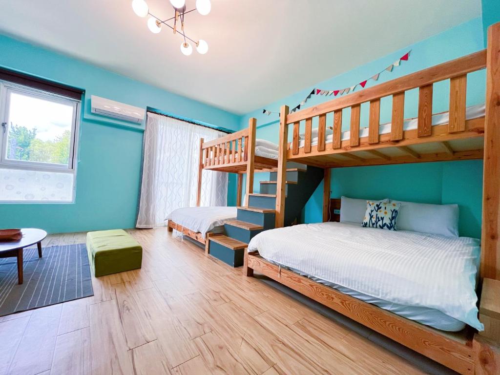 2 Etagenbetten in einem Zimmer mit blauen Wänden in der Unterkunft 艾希兒民宿 l小家庭可包棟 in Taitung