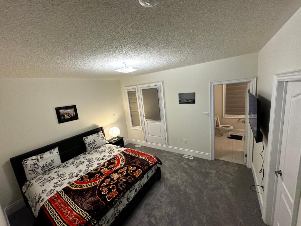 a bedroom with a bed and a television in it at C&M LUXURY HOME in Brampton