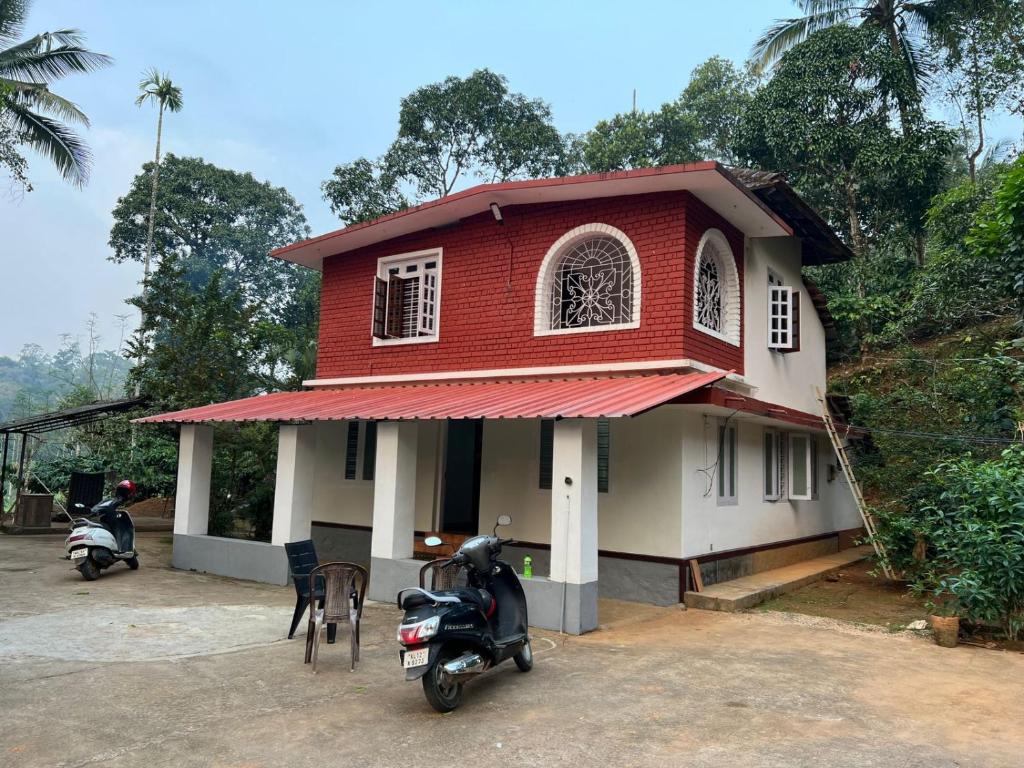 ein Haus mit einem Roller, der davor geparkt ist in der Unterkunft ZenHost in Kalpatta
