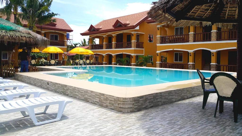 a swimming pool in front of a building at SLAM'S Garden Dive Resort in Malapascua Island