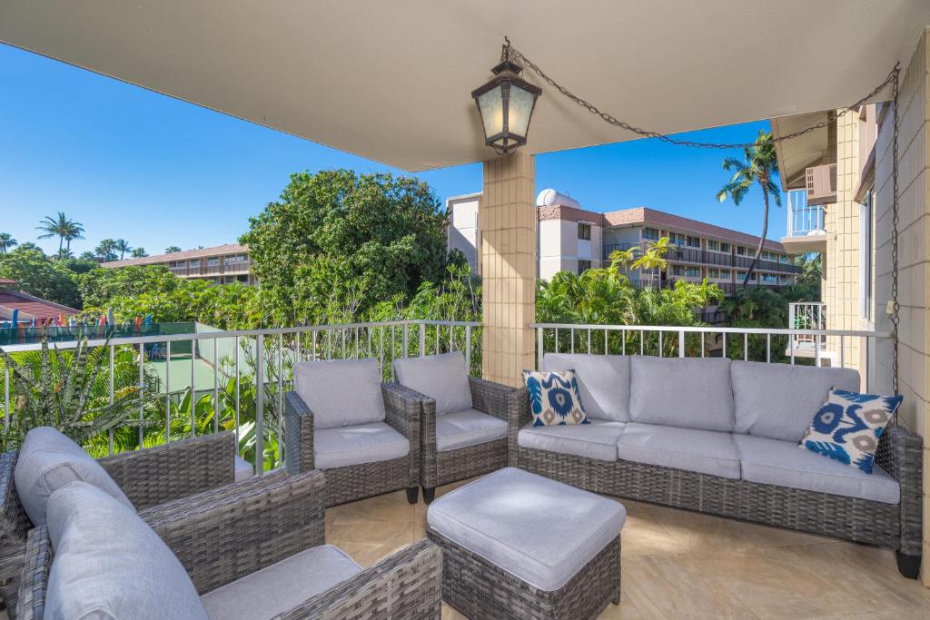 a patio with couches and chairs on a balcony at A-312 Haleakala Shores in Wailea