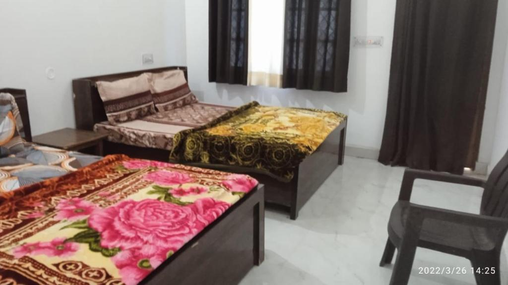 a living room with two beds and a chair at Haridwar and kedarnath dharmshala in Haridwār