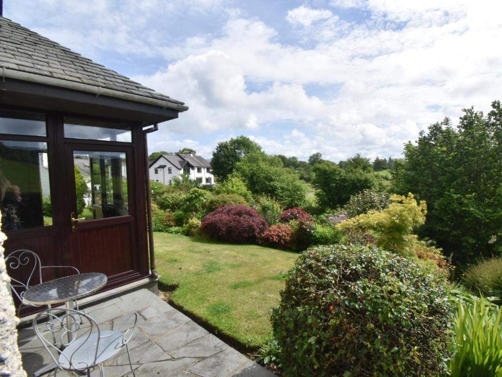 uma vista para um jardim a partir do alpendre de uma casa em 1 Bed in Outgate and Tarn Hows LLH50 em Hawkshead