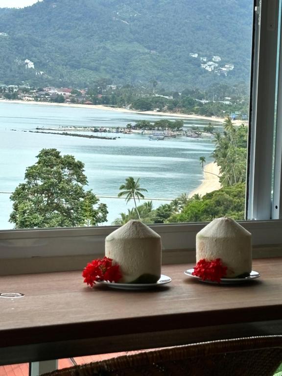 deux gâteaux assis sur une table devant une fenêtre dans l'établissement Grand view @lamaibeach, à Koh Samui 