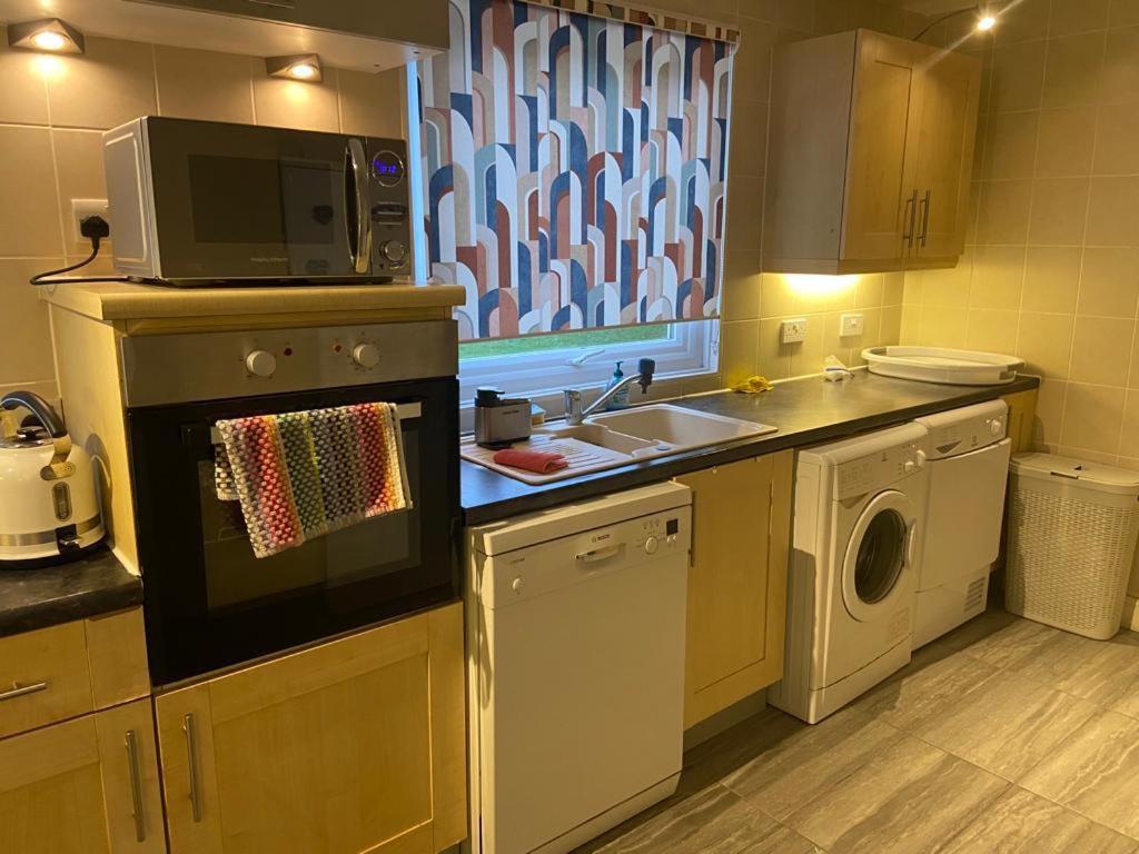 a kitchen with a sink and a microwave at TJ House in Sherborne Saint John