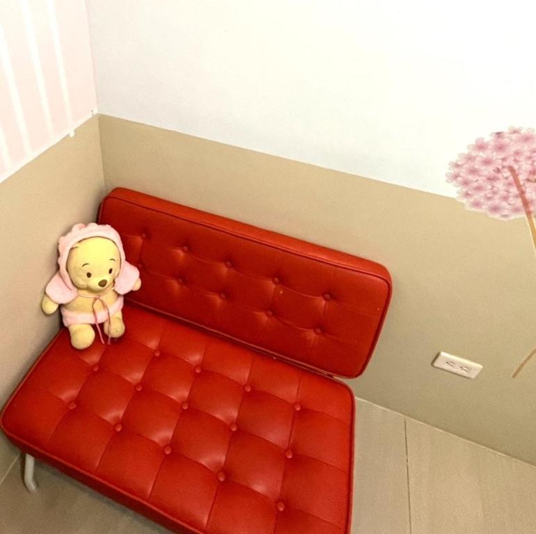 a red couch with a teddy bear sitting on it at 萩閣民宿Sara&#39;s House走路可到夜市近市區好停車 in Hualien City