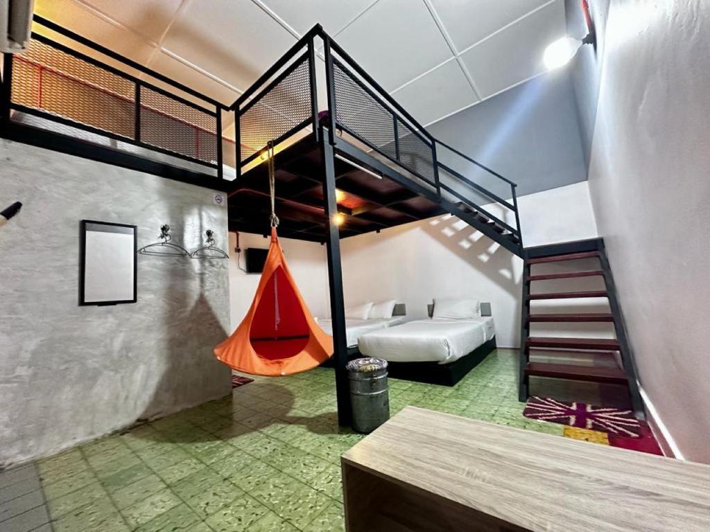 a loft bedroom with a staircase and a swing at Ardour Lodge "A" Wing in Tanjung Bungah