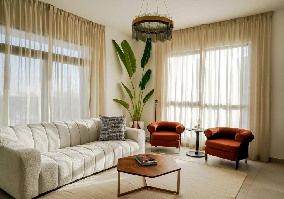 - un salon avec un canapé, des chaises et une table dans l'établissement Brand New l Stylish and Spacious 2BR in Madinat Jumeirah, à Dubaï
