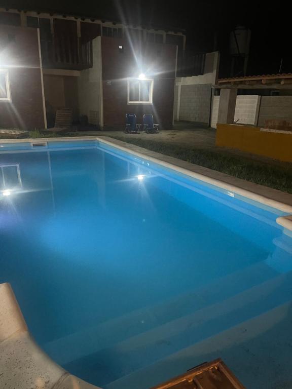 an empty swimming pool at night with lights at Cab, SE ,1 in Villa Los Aromos