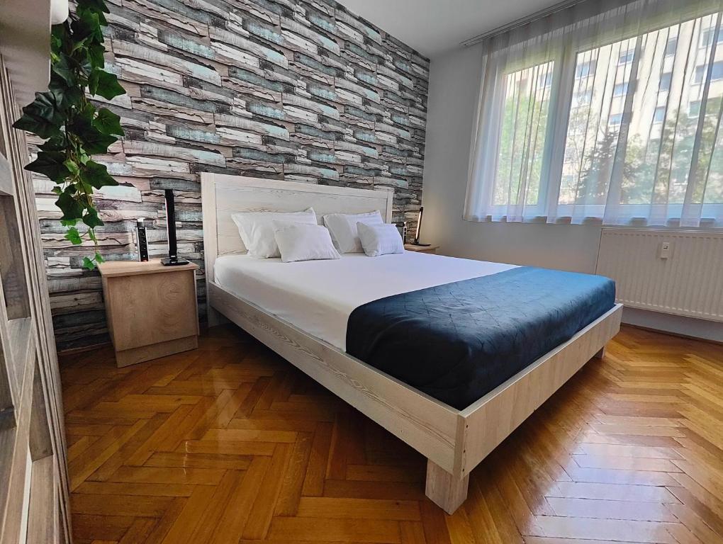 ein Schlafzimmer mit einem großen Bett und einer Ziegelwand in der Unterkunft ""Comfort 14'' in Miskolc