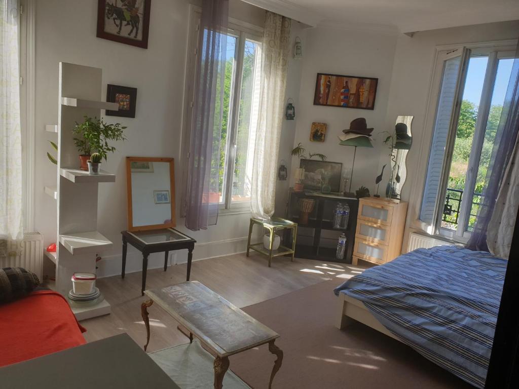 um quarto com uma cama e um quarto com janelas em Villa proche JO 2024 em La Courneuve