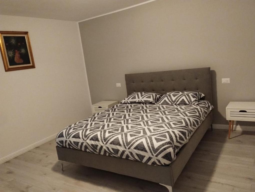 1 dormitorio con 1 cama con edredón blanco y negro en Casa Mont Blanc apartament 1, en Cavnic