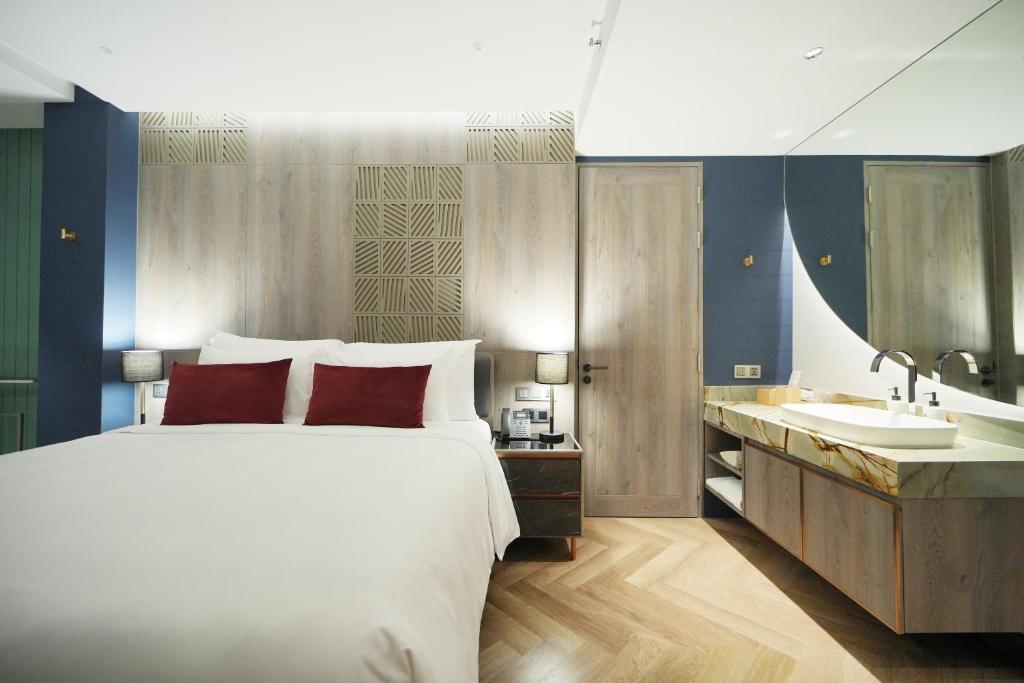 A front-facing bedroom view with the bed beside an open vanity and entry door.