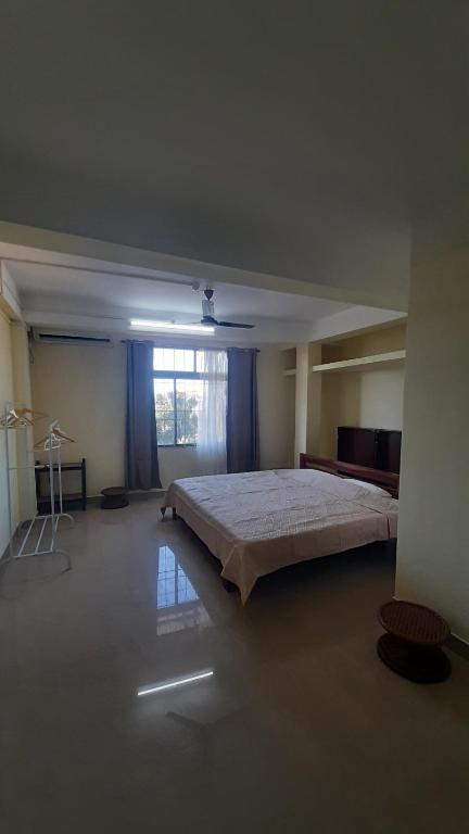 1 dormitorio grande con 1 cama grande y ventana en m&b homestay, en Itānagar