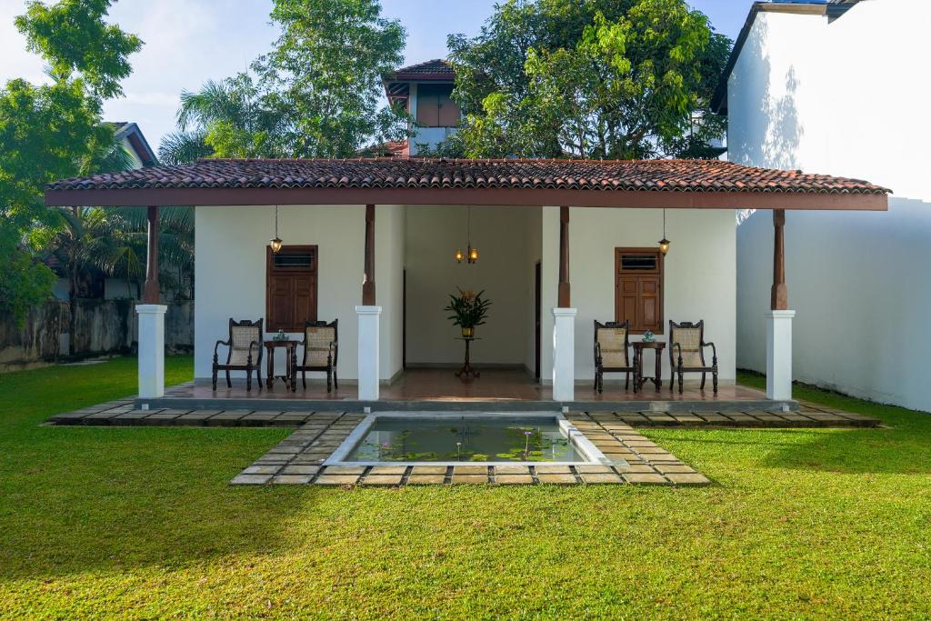 ein Haus mit einer Terrasse, einem Tisch und Stühlen in der Unterkunft Summer House - Private villa close to International Airport BIA in Ja-Ela