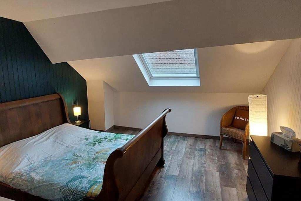 um quarto com uma cama grande e uma clarabóia em Logement atypique à Ornans em Ornans