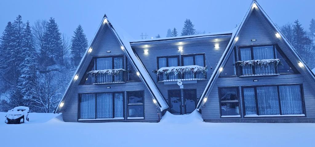 une grande maison dans la neige dans l'établissement Cabana din Vale Arieseni Apuseni, à Arieşeni