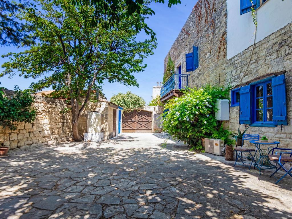 a courtyard in a house with blue doors and a tree at Cornaro House in Arsos
