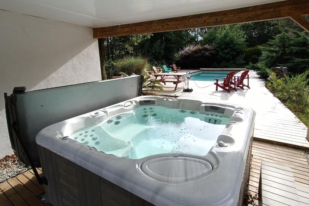 einen Whirlpool auf einer Terrasse neben einem Pool in der Unterkunft 200 M With Terrace And Pool in Soustons
