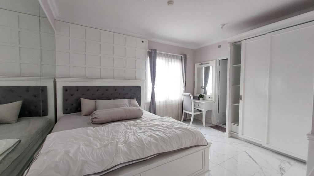 - une chambre blanche avec un lit et une fenêtre dans l'établissement Homey Cozy 3 Bedrooms Apt 125m², à Bandung