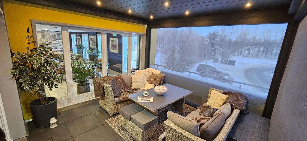 Zimmer mit Stühlen, einem Tisch und einem großen Fenster in der Unterkunft Hotel-Restaurant Stand'Inn in Foetz