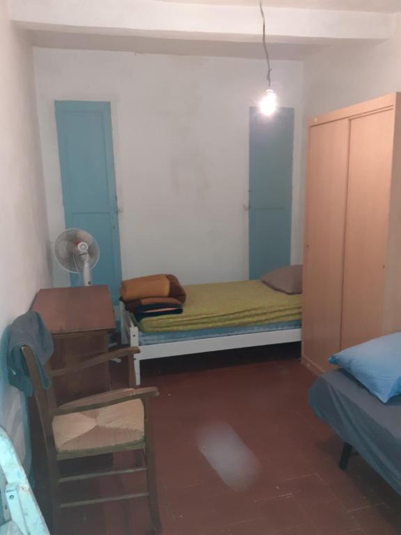 Cette petite chambre comprend un lit et une chaise. dans l'établissement Dortoirs Hommes, à Béziers