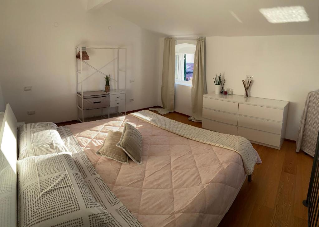 a white bedroom with a large bed and a window at Magici ricordi-Bordighera in Bordighera