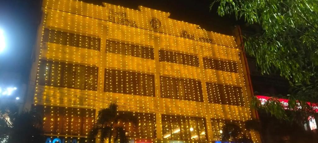 a tall yellow building with lights on it at vella marina group of hotels Surya in Amritsar