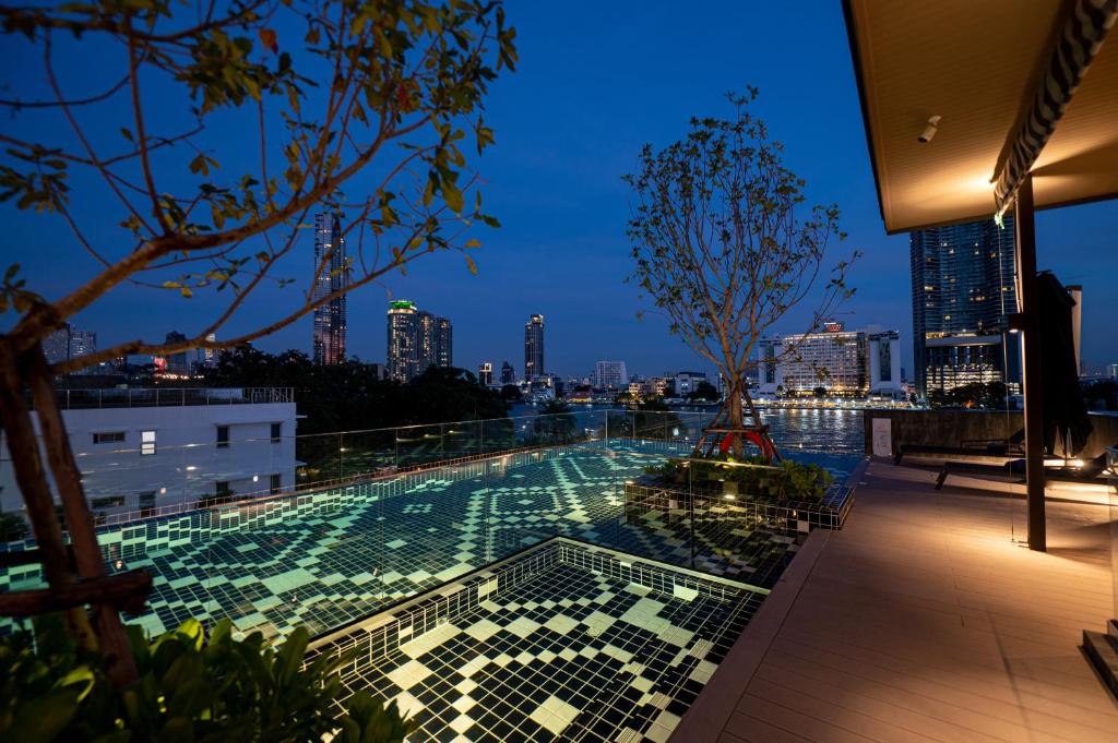 A rooftop pool overlooking the river and city at blue hour.