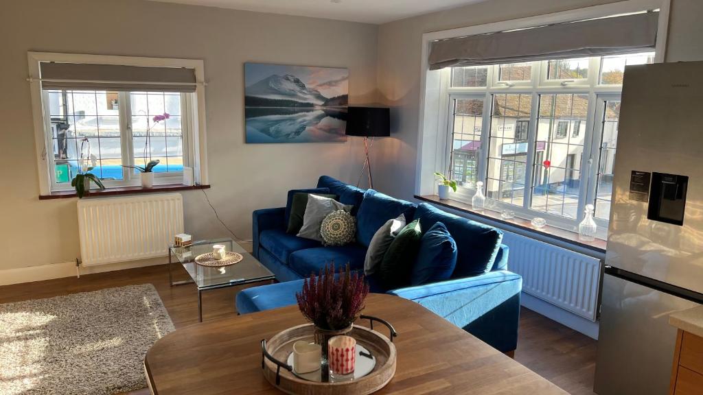 a living room with a blue couch and a table at Cosy Corner in Midhurst