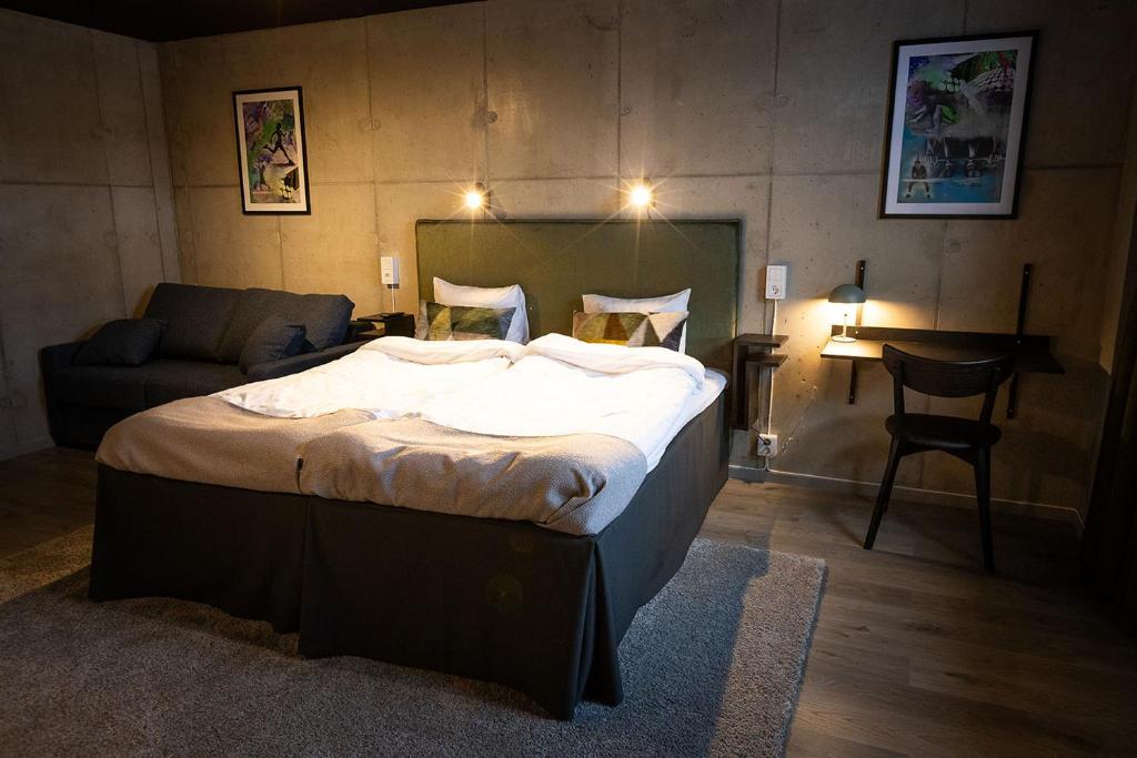 - une chambre avec un lit, un canapé et une table dans l'établissement Playhotel, à Mjölby