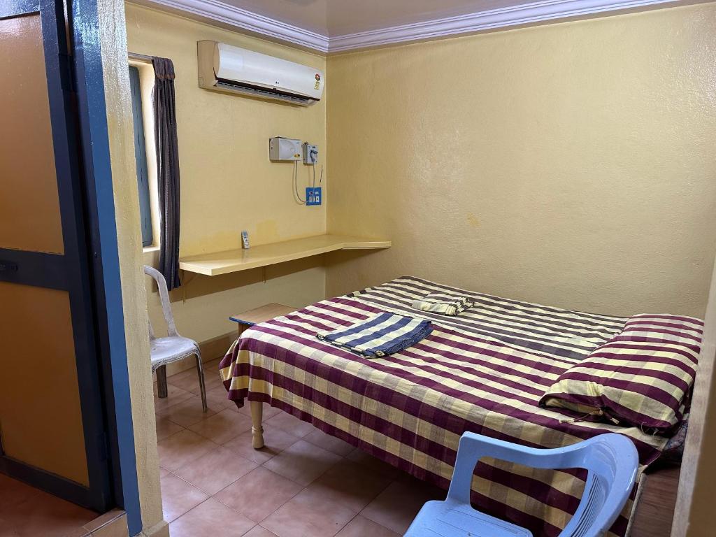 a small room with a bed and a chair at Navata Lodge in Pulivendla