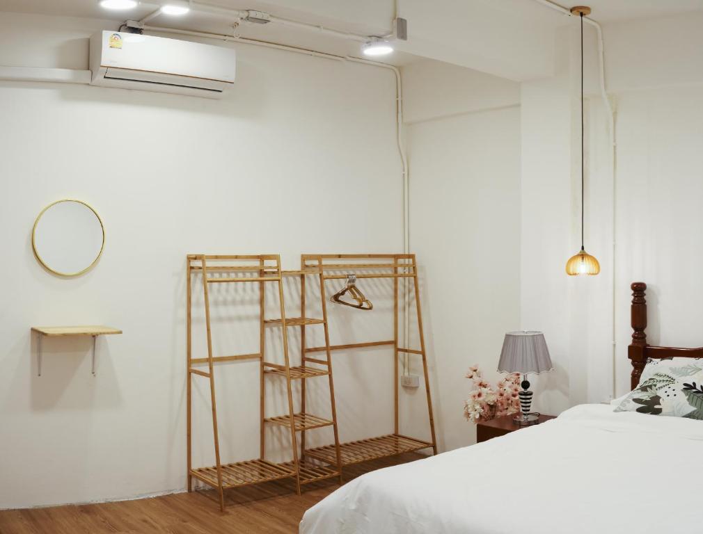 1 dormitorio con 2 escaleras de madera junto a una cama en Private Full-Floor Spacious 5BR in China Town, en Bangkok