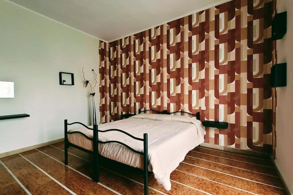 a bedroom with a bed with a wooden wall at Flat 15km Airport Milan BGY in Cologno al Serio