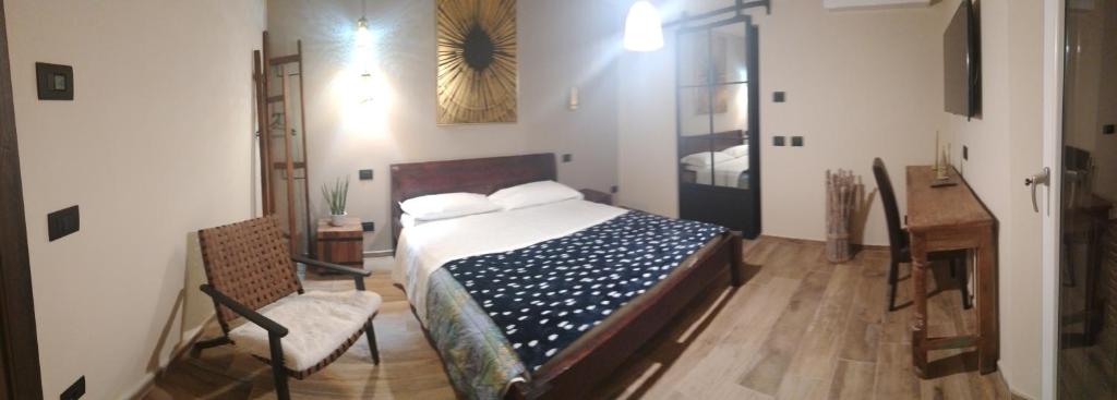 1 dormitorio con cama, mesa y escritorio en La Signoria Relais, en Ferrara