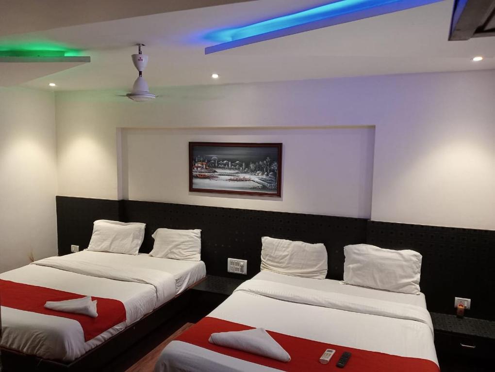 a room with two beds and a tv on the wall at Terminus Square in Kurla
