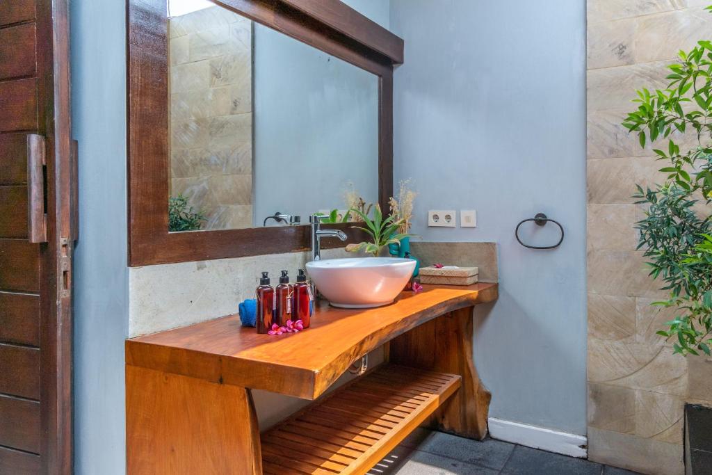 a bathroom with a sink and a mirror at Bale Sampan Boutique Bungalows in Gili Trawangan