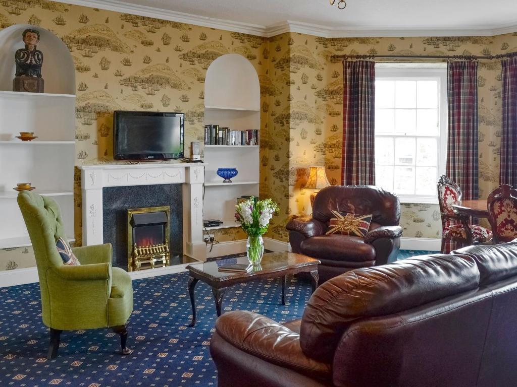 a living room with leather furniture and a fireplace at Nelson - Fdg in Ilfracombe