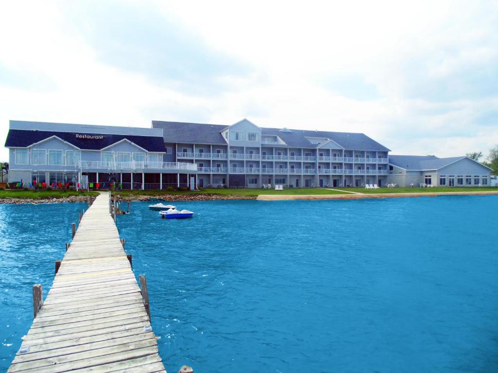 a dock in front of a large building on the water at Lakeside Resort & Conference Center in Houghton Lake