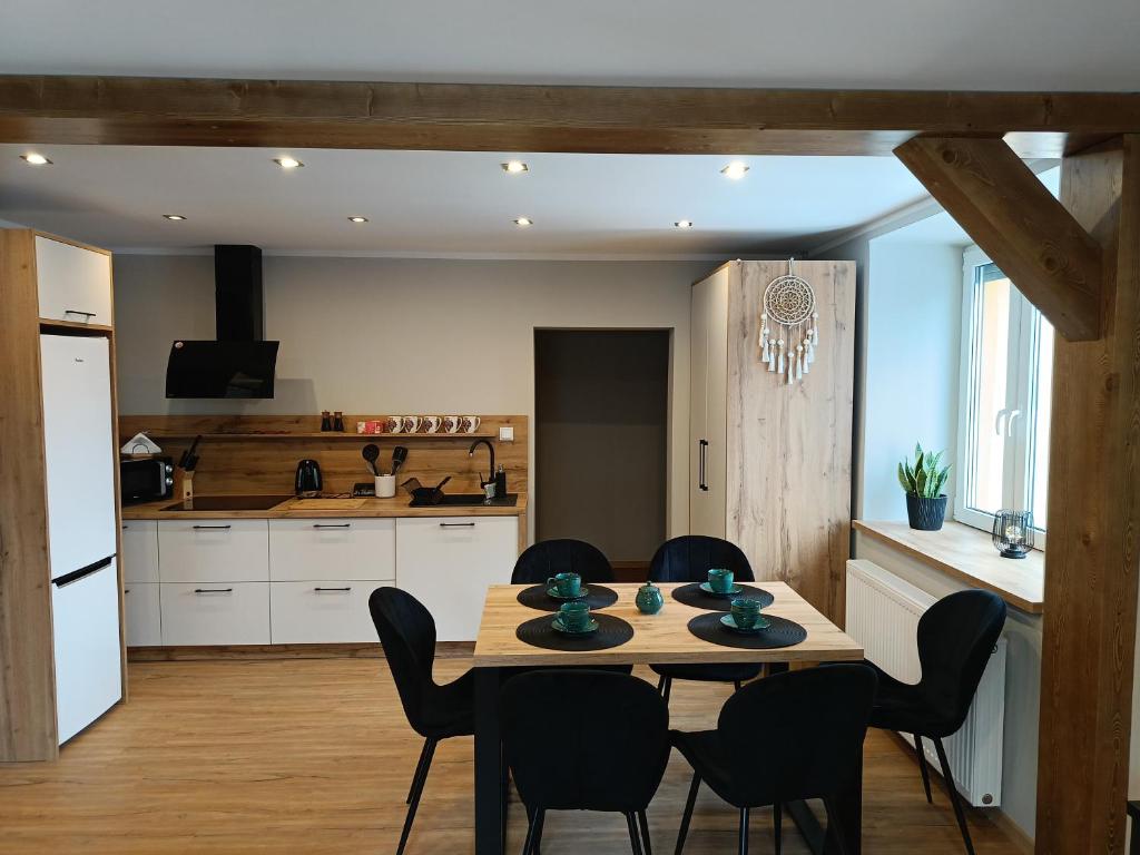 uma cozinha e sala de jantar com mesa e cadeiras em Brenna Pogodny Dom em Górki Wielkie